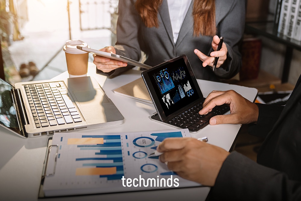 Team analysiert Diagramme mit Laptop und Tablet, Jobprofil Business Analyst