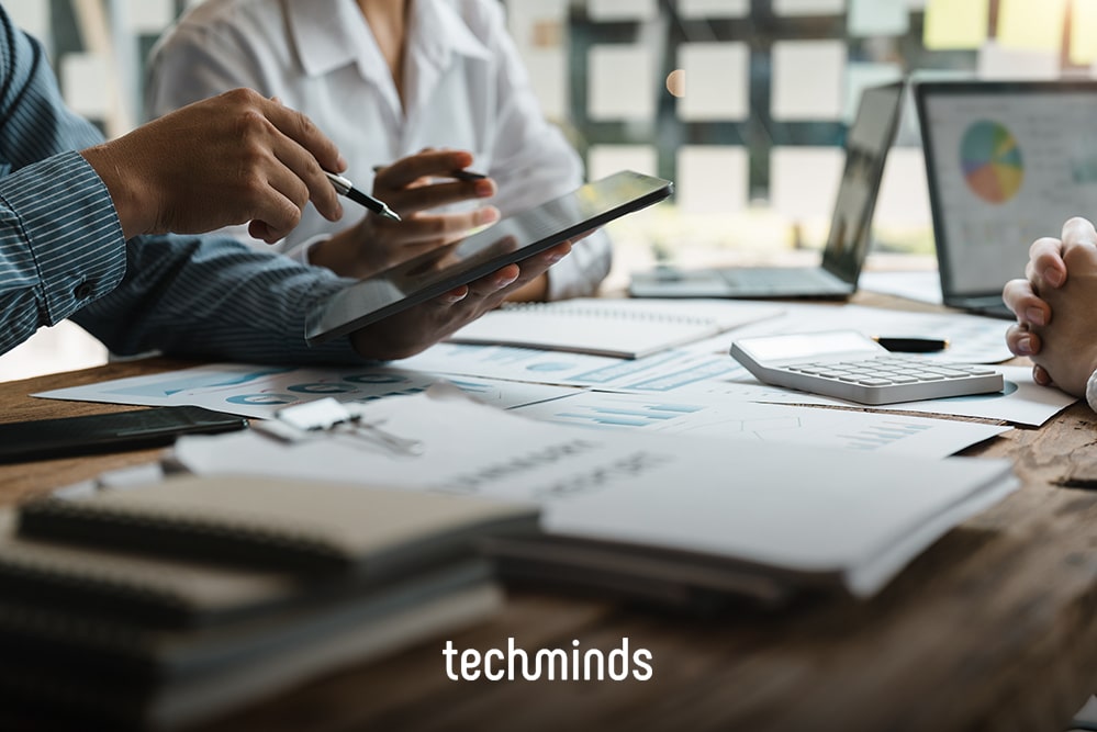 Team plant am Tisch mit Unterlagen, Diagrammen und Tablet, Jobprofil Head of Product