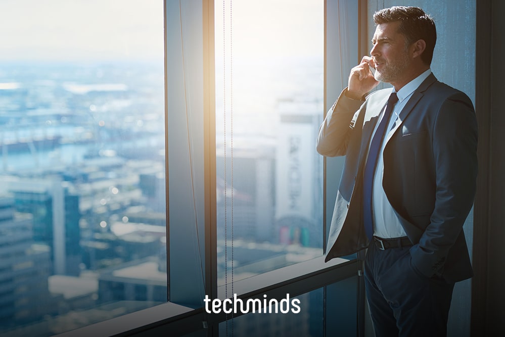 Key Account Manager telefoniert am Fenster eines Hochhausbüros, Jobprofil Key Account Manager