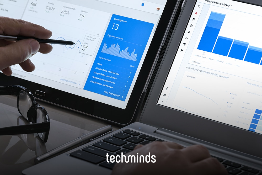 Hand mit Stift vor Laptop und Monitor mit Analytics-Dashboard, Jobprofil SEO-Manager