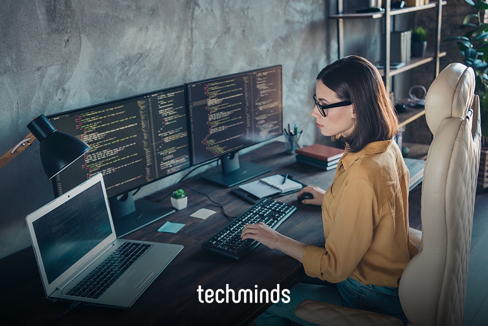 Systemadministratorin an mehreren Monitoren mit Code, Jobprofil IT Systemadministrator