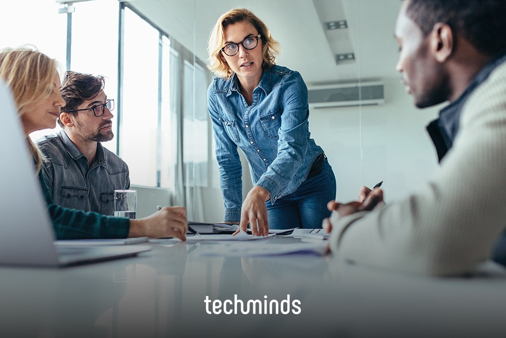 Team Lead leitet die Besprechung am Tisch mit ihrem Team, Jobprofil Team Lead