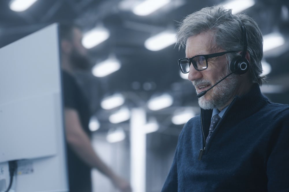 IT-Administrator mit Headset im Rechenzentrum