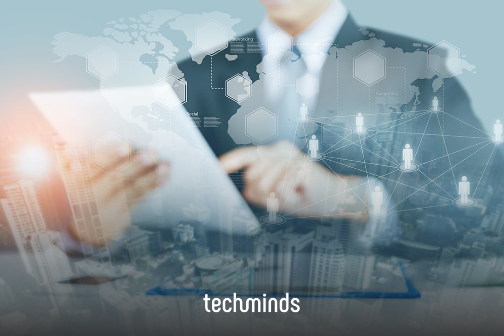 Hände am Tablet über einer Weltkarte mit Netzwerkpunkten, dazu das TechMinds-Logo