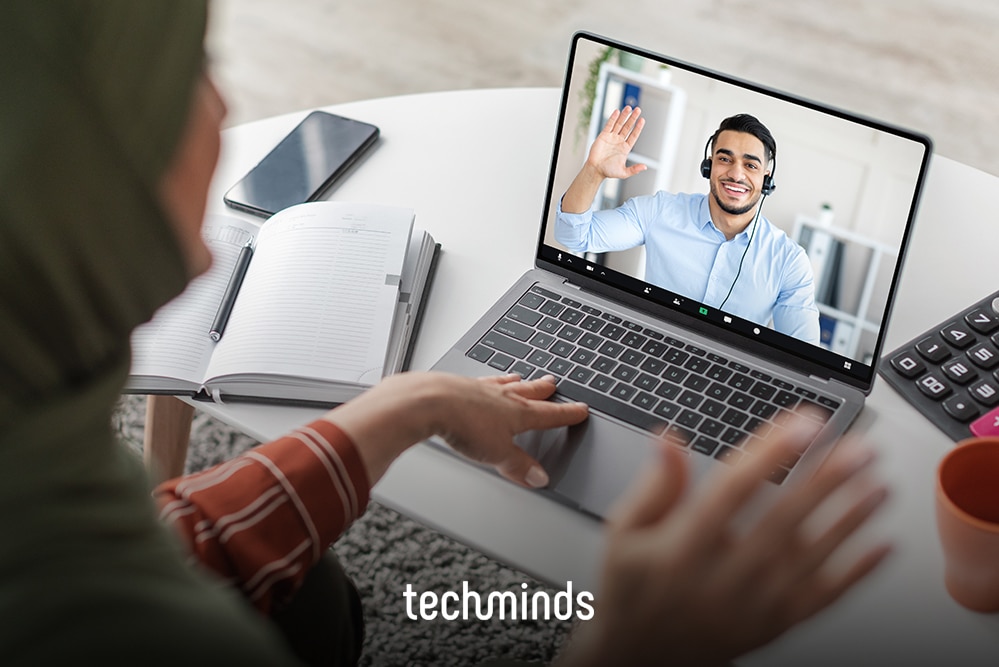 Videogespräch am Laptop mit einem winkenden Kandidaten auf dem Bildschirm