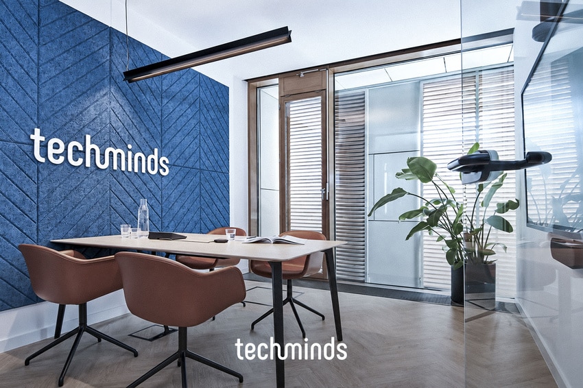 Besprechungsraum im TechMinds Büro Hamburg mit blauer Akustikwand und Logo