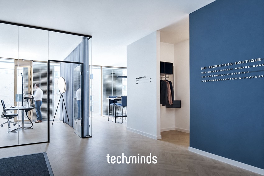 Eingangsbereich im TechMinds Büro Hamburg mit blauer Akzentwand und Glasfront