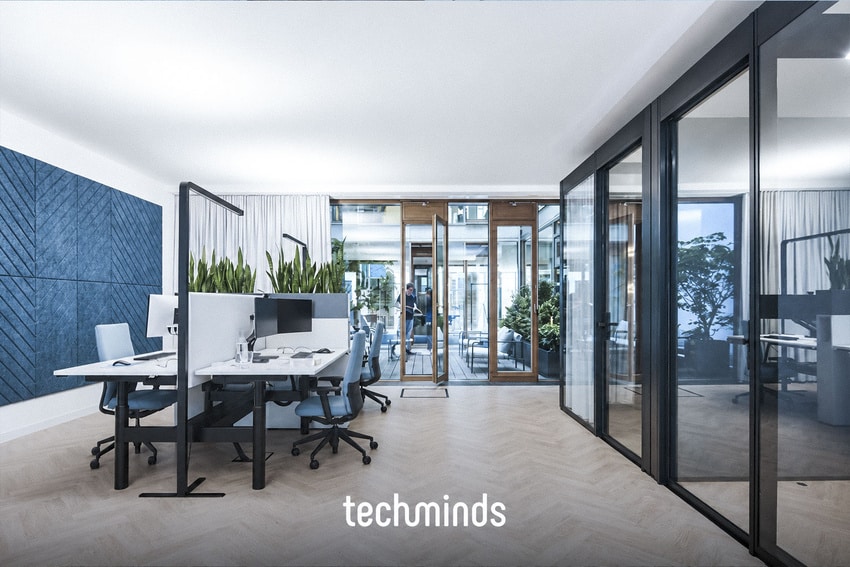 Offener Arbeitsbereich im TechMinds Büro Hamburg mit Schreibtischen und blauer Akustikwand