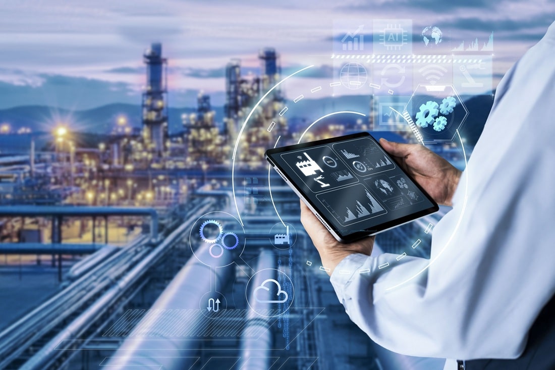 Hände mit Tablet vor einer Chemieanlage, Headhunter Chemieindustrie und Verfahrenstechnik
