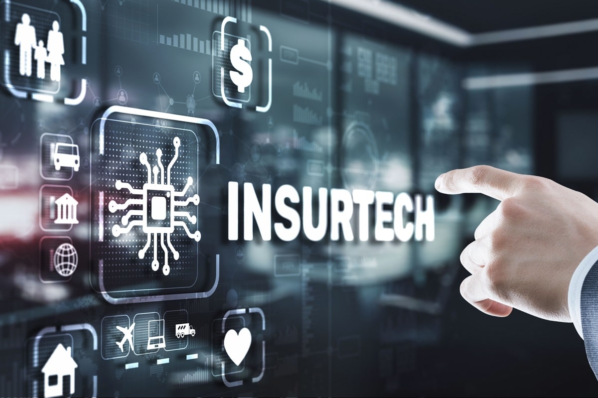 Hand zeigt auf einen InsurTech-Schriftzug mit Versicherungssymbolen