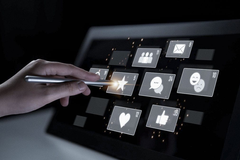 Hand tippt auf ein Tablet mit Mediensymbolen
