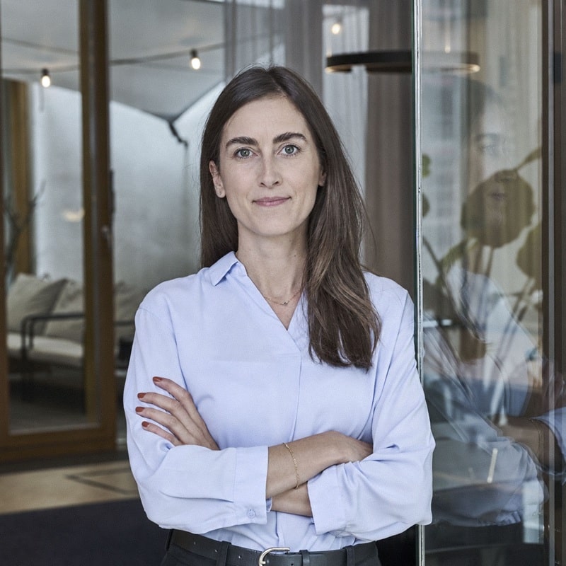 Nadine Wiegner vom TechMinds Team steht mit verschränkten Armen im modernen Büro – über TechMinds.