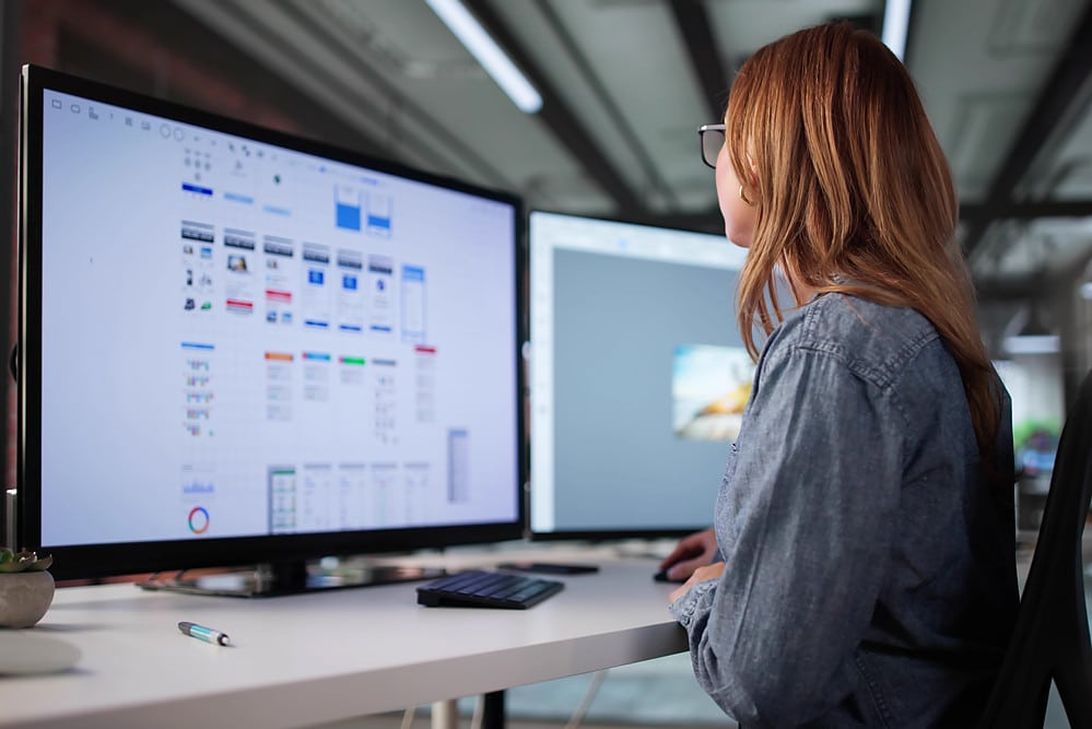 UX Designer gestaltet Nutzeroberflächen und Wireframes für digitale Produkte am Bildschirm.